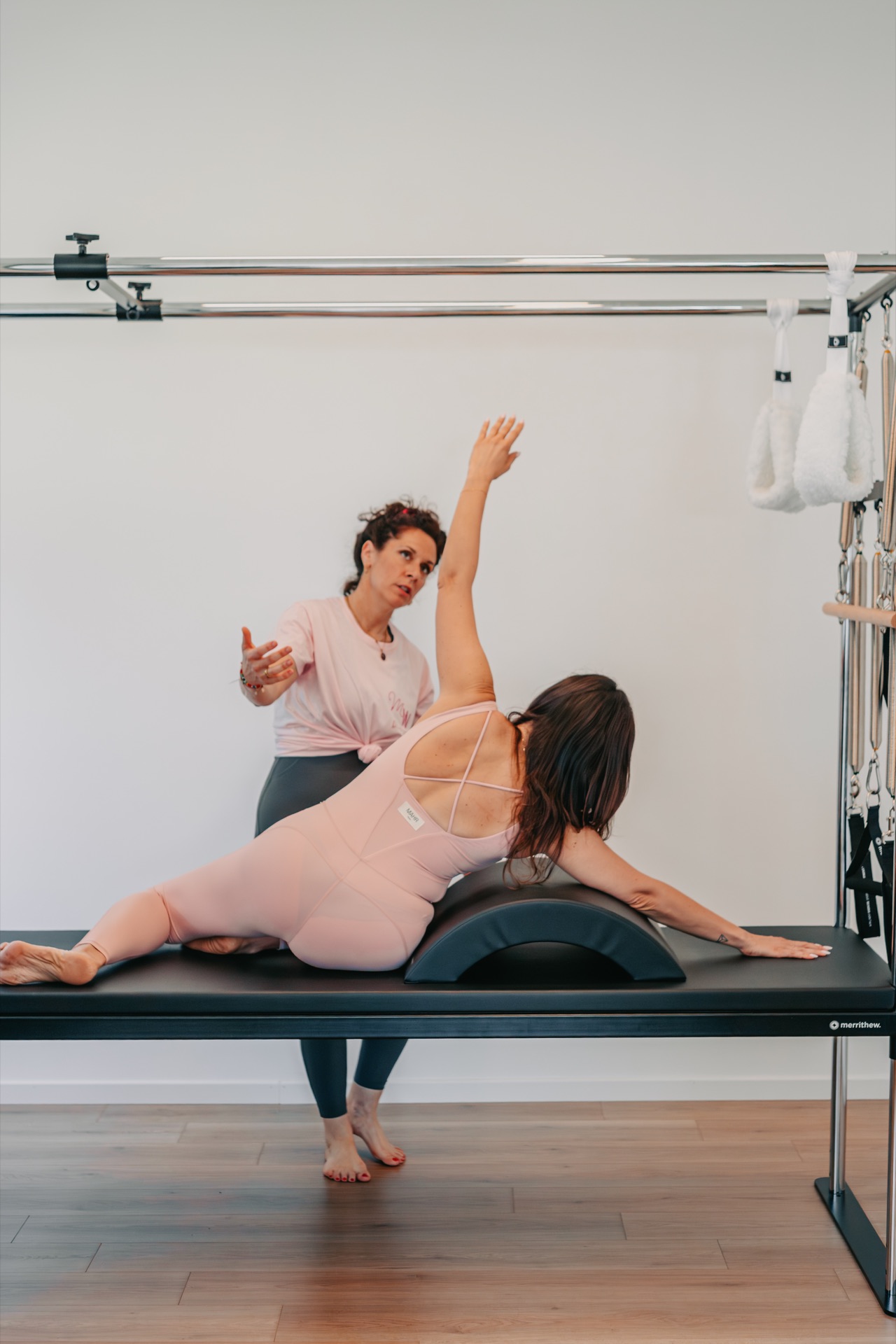 Allungamento laterale sull'arc barrel guidato dall'istruttrice durante una lezione di Matwork allo studio Marilyn's Workout, Milano