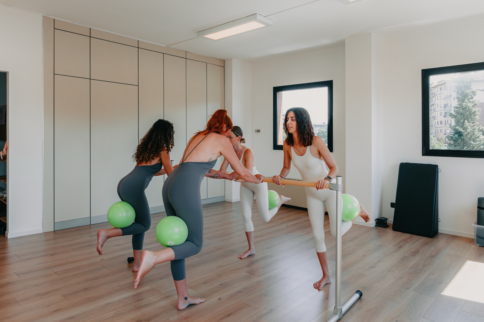 Esercizi di core training alla sbarra con small ball durante la lezione allo studio Marilyn's Workout, Milano