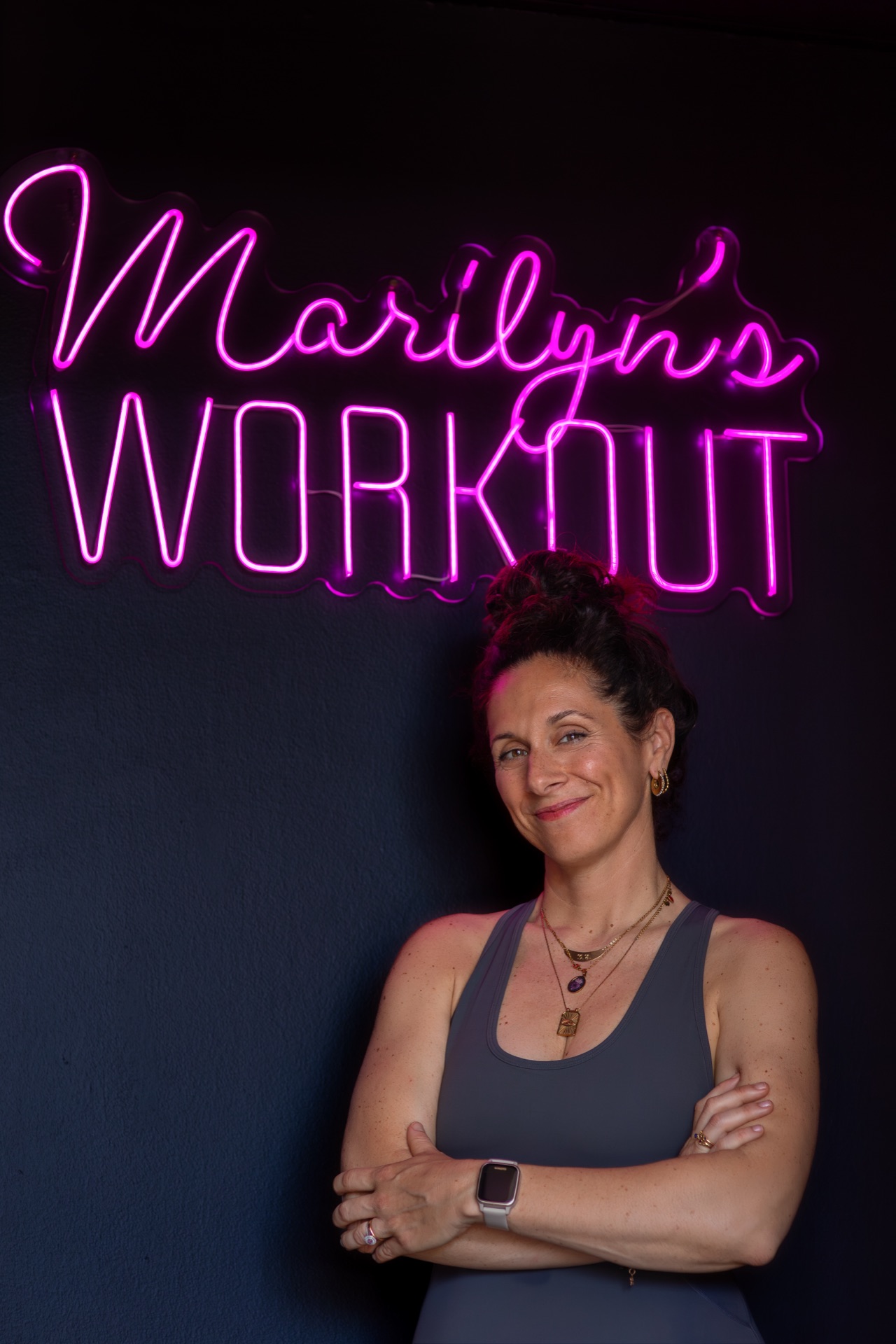 Roberta, titolare e istruttrice di Marilyn's Workout, davanti all'insegna al neon dello studio Pilates a Milano